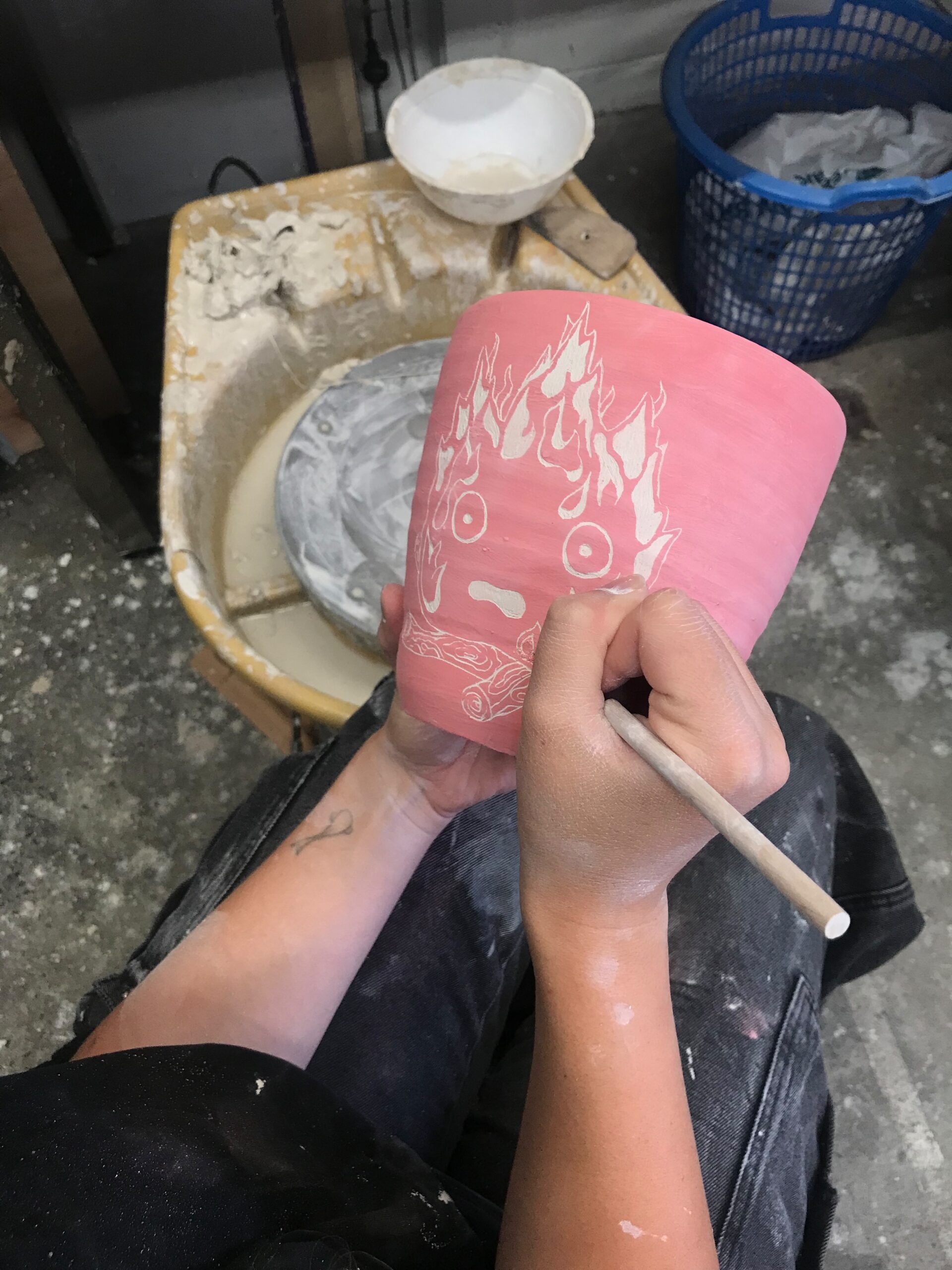 Image of a pink ceramic pot being decorated at the Artosaurus Studio and workshop space as part of their Artist Profile with Art Trails Tasmania