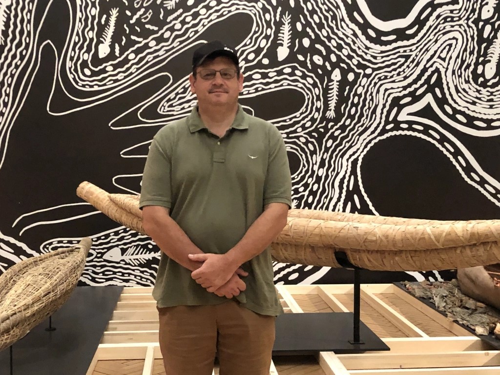 Image shows Dean Greeno in front of his work