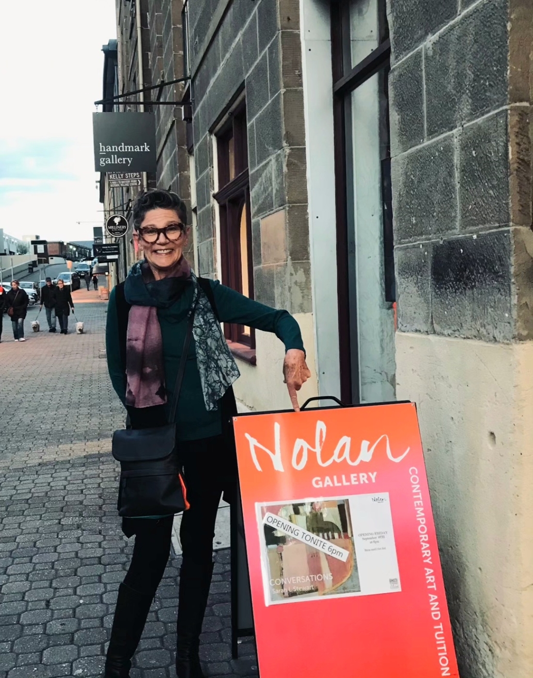 Image shows Bruny Island artist Sarah L Stewart outside the Nolan Gallery in Hobart for her solo exhibition in her Artist Profile Story for Art Trails Tasmania