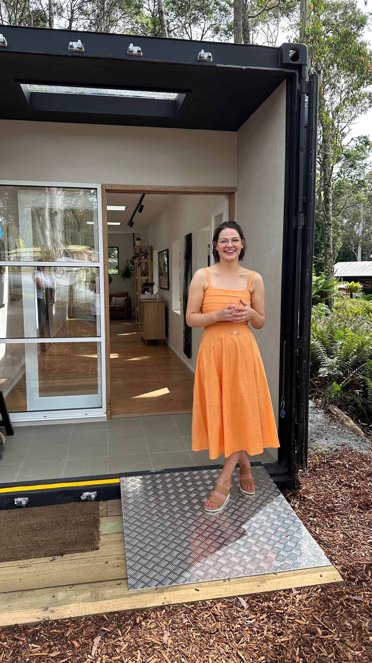 Image shows galleriest Aimee in front of her studio in the bush made from a shipping container for the Gallery Profile Art Meets Healing at the Blue Tree Gallery Art Trails Tasmania