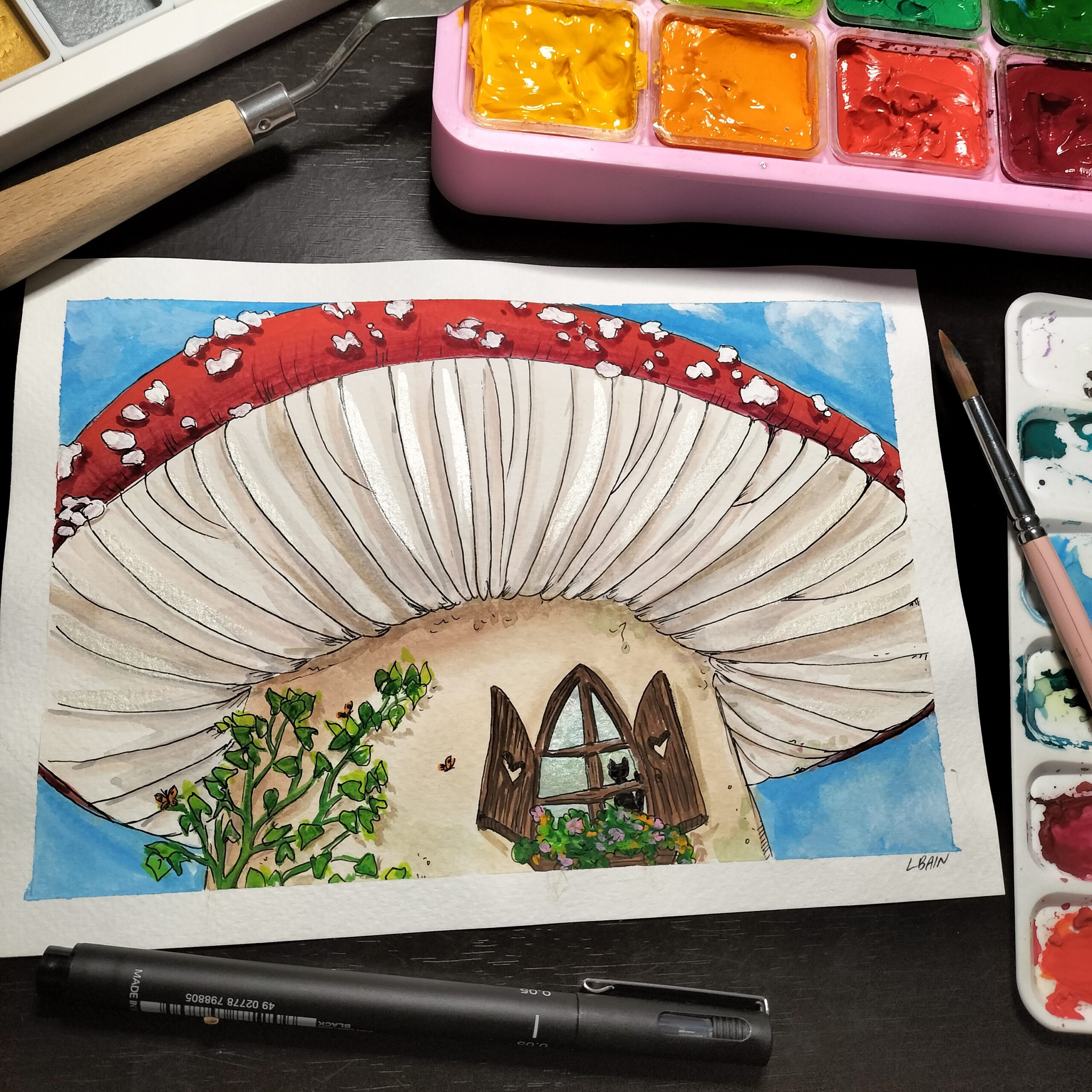 Image shows a mushroom painting alongside a pan of paints and a palette knife for the Artist Profile Crafting Magical Worlds and Nature's Wonders with Laurinda Brooker Art Trails Tasmania