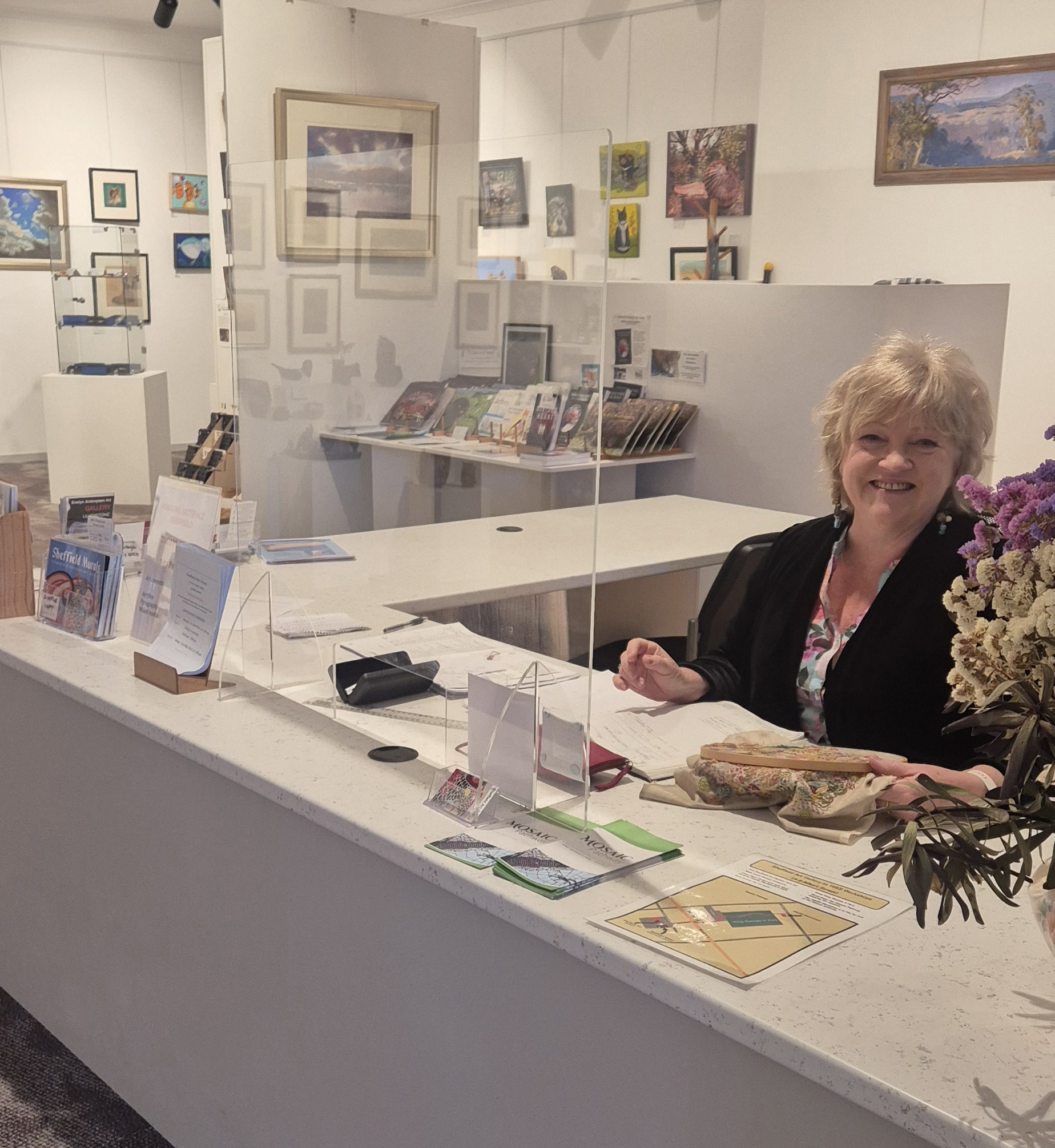 Images shows inside the gallery space at the front desk the Gallery Profile story Discover Local talent, vibrant spaces and community connection at the Sheffield Art Gallery Art Trails Tasmania for the Artists Ensemble membership