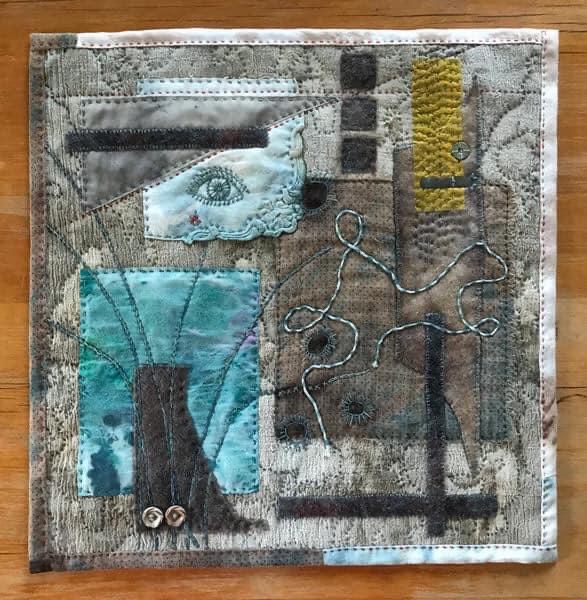 Image shows of a mixed media artwork of eco dyed fabric slow stitched in the colours of greys, blues and yellows with for the Artist Profile of Renowned Nature Inspired Textile Artist Rita Summers in her Art Trails Tasmania story