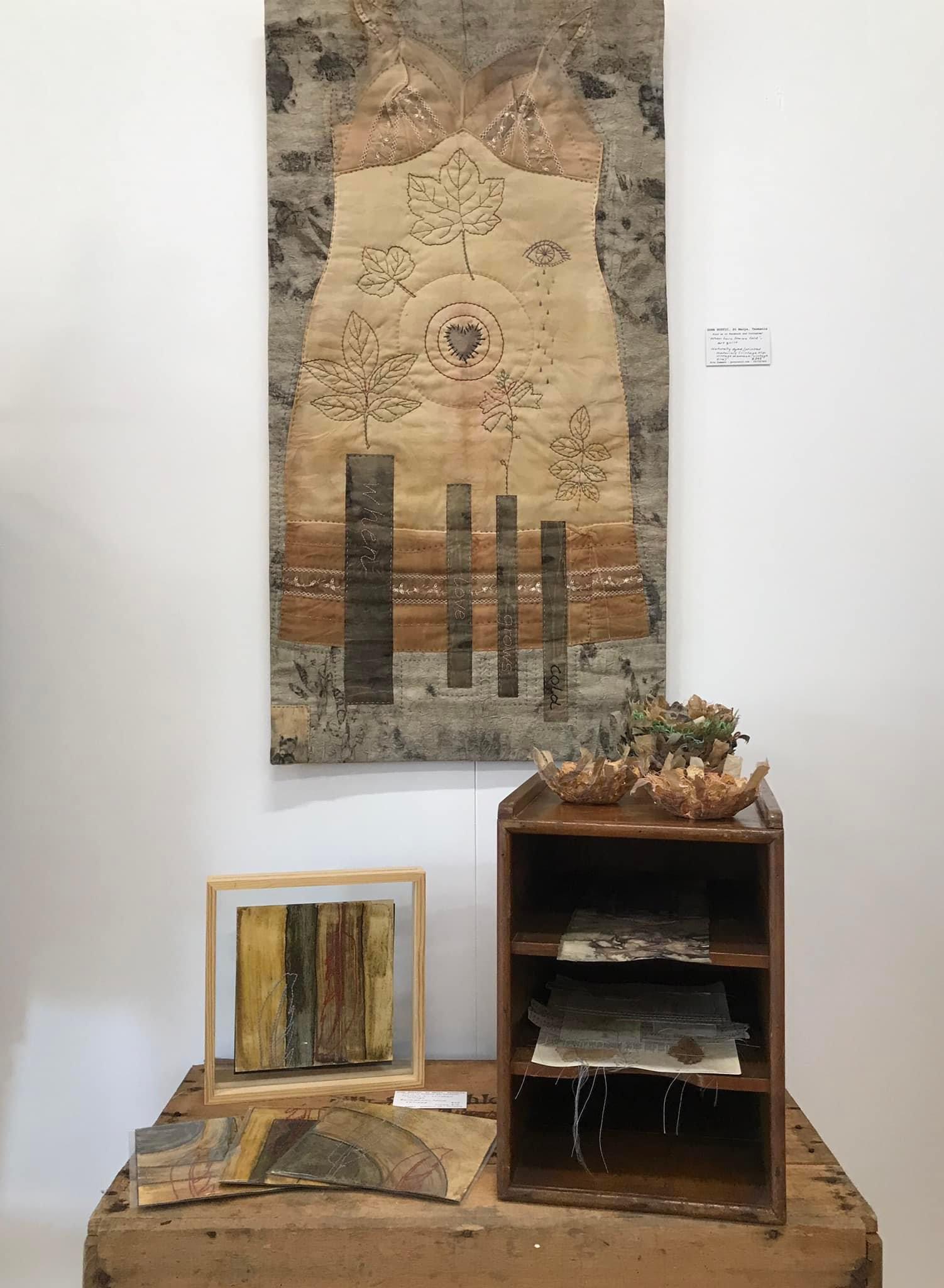 Image shows a wall hanging of mixed media artworks of eco dyed fabric slow stitched for the Artist Profile of Renowned Nature Inspired Textile Artist Rita Summers in her Art Trails Tasmania story