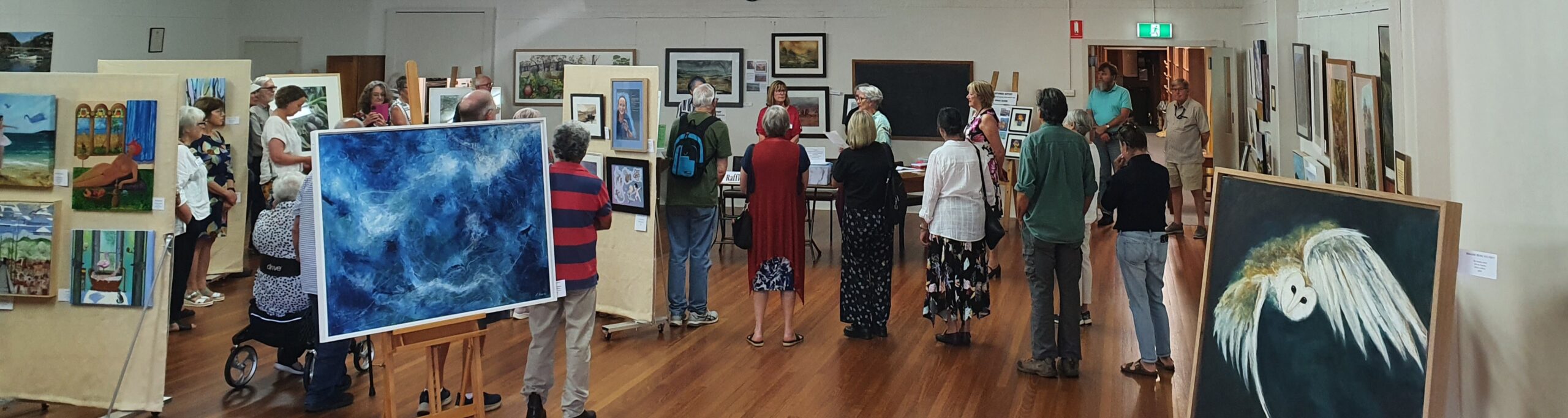 Image is of people at an art exhibition opening for the Art Society Profile Join the Launceston Art Society's Journey Through Education, Workshops and Exhibitions Art Trails Tasmania